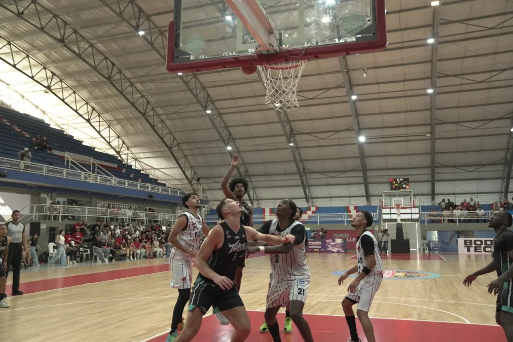 Jugador de Toros del Valle salta y suelta el balón cerca del aro ante Piratas