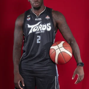 Jugador de Toros del Valle con la camiseta visitante negra oficial 2026 de frente sobre fondo rojo