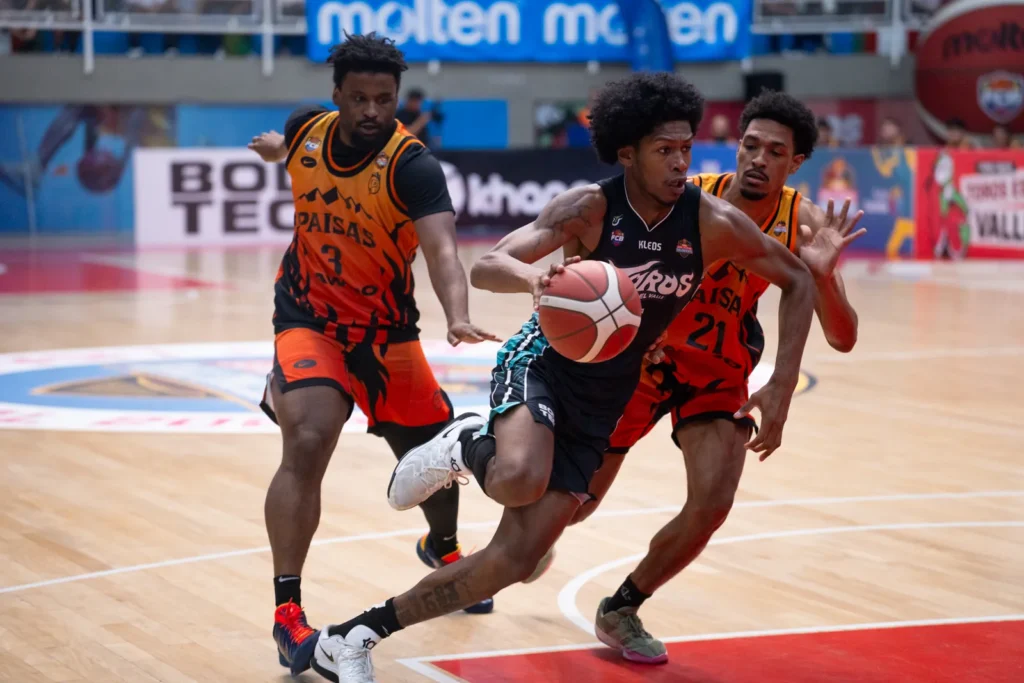 Jugador de Toros del Valle penetra entre dos defensas de Paisas Basketball en Cali