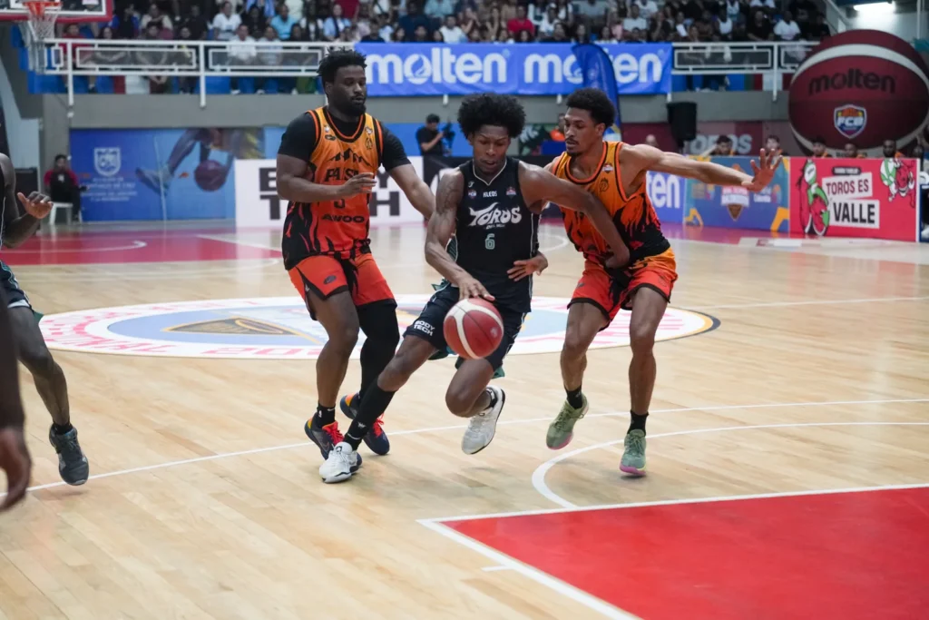 Jugador de Toros del Valle avanza en transicion ante la defensa de Paisas Basketball en Cali