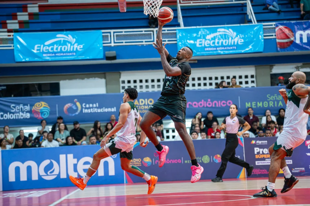 Jugador de Toros del Valle se eleva hacia el aro de Paisas Basketball en el Evangelista Mora