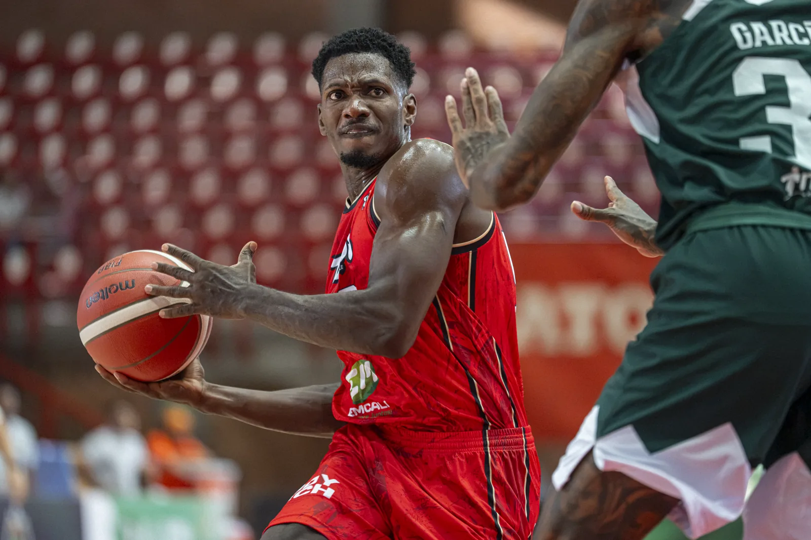 Jugador de Toros del Valle protege el balón ante la marca de Paisas Basketball en Medellín