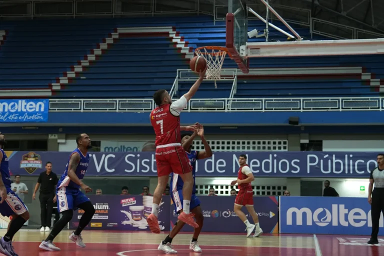 Darwin Blanco, #7 de Toros del Valle, sube a la bandeja ante la marca de un jugador de Sabios de Manizales