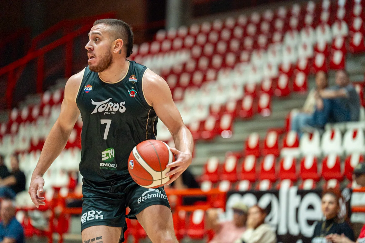 Darwin Blanco, #7 de Toros del Valle, observa la defensa mientras ataca con el balón ante Paisas Basketball