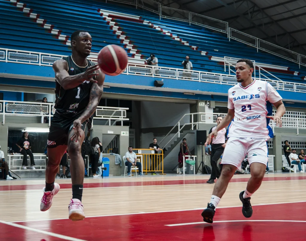 Martín Cabezas (#1) de Toros del Valle pasa el balón en el ataque ante un defensor de Sabios de Manizales
