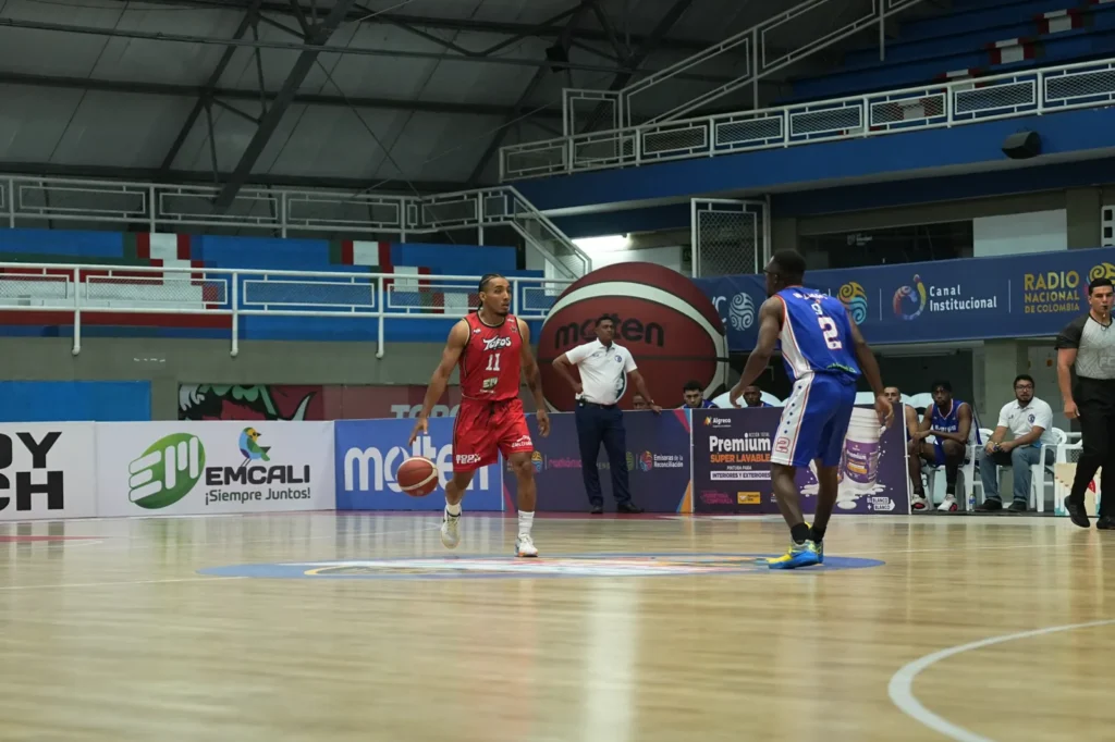 Samuel Mojica, #11 de Toros del Valle, bota el balón frente a un defensor de Sabios de Manizales