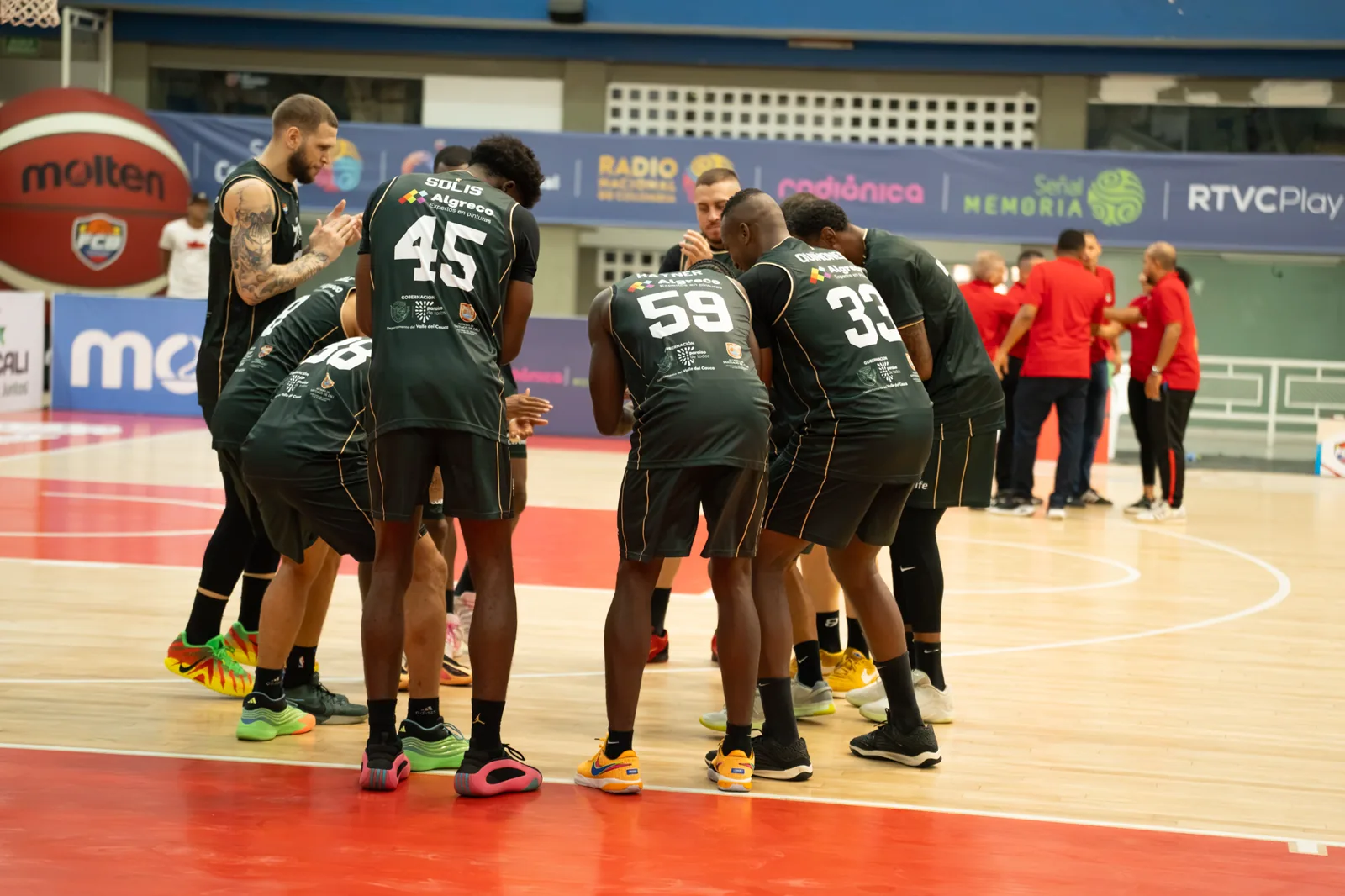 Jugadores de Toros del Valle se concentran en círculo sobre la cancha del Coliseo Evangelista Mora antes del duelo ante Caribbean Storm