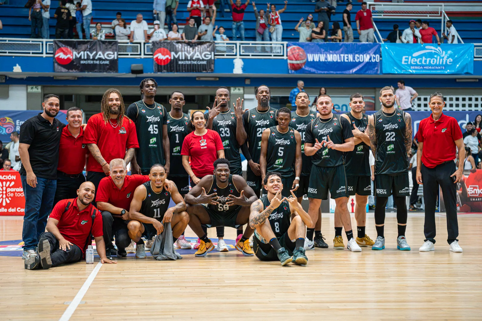 Jugadores y cuerpo técnico de Toros del Valle posan en la cancha del Evangelista Mora tras vencer a Paisas Basketball