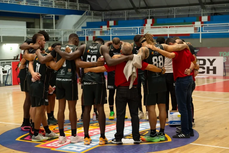 Jugador de Toros del Valle lanza al aro mientras defienden jugadores de Sabios de Manizales