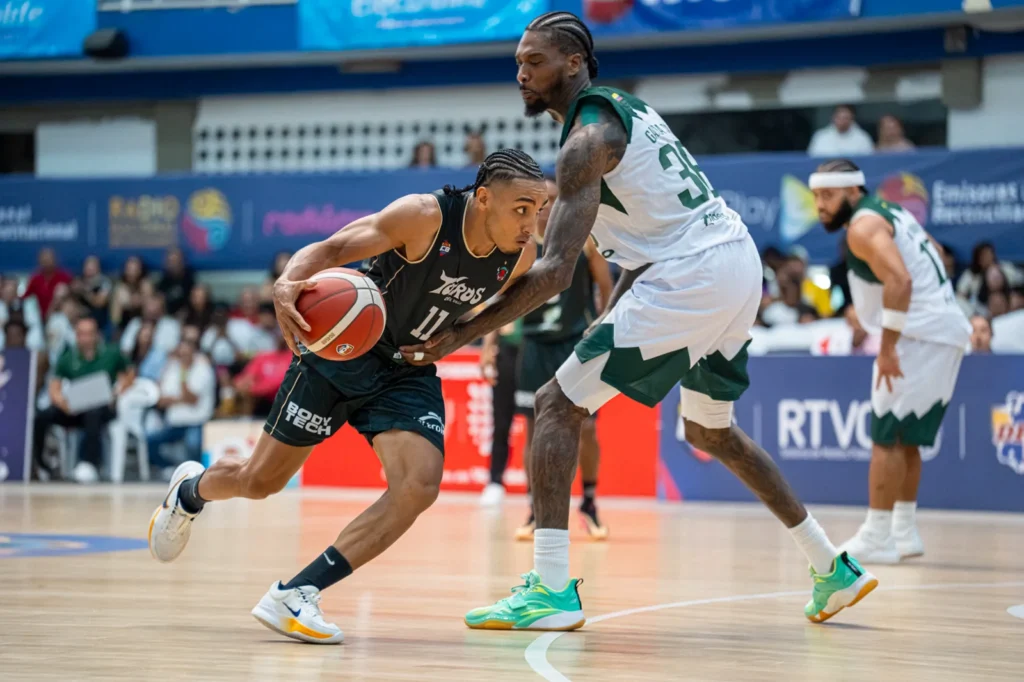 Samuel Mojica supera con el bal�n a un defensor de Paisas Basketball en el Evangelista Mora