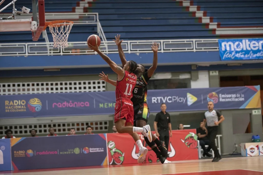 Samuel Mojica ataca el aro con una bandeja ante la defensa de Caribbean Storm