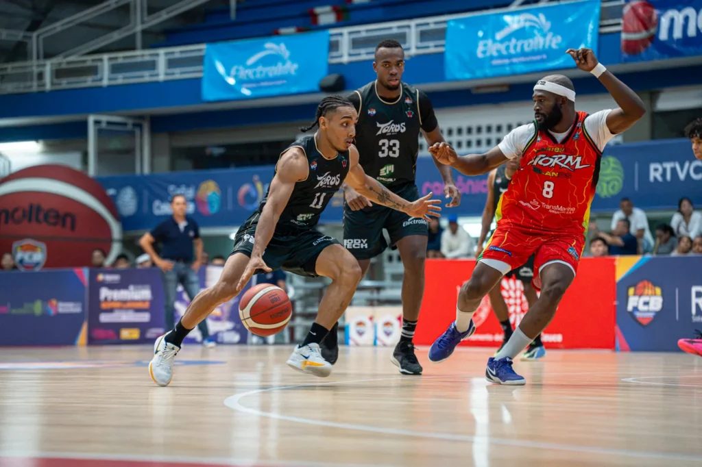 Samuel Mojica conduce el balón en ataque de Toros del Valle ante Caribbean Storm mientras un rival lo persigue