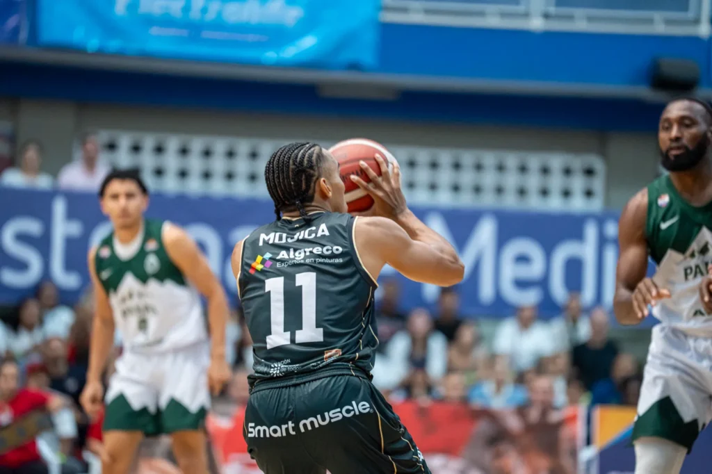 Samuel Mojica arma el lanzamiento con el bal�n ante la marca de Paisas Basketball