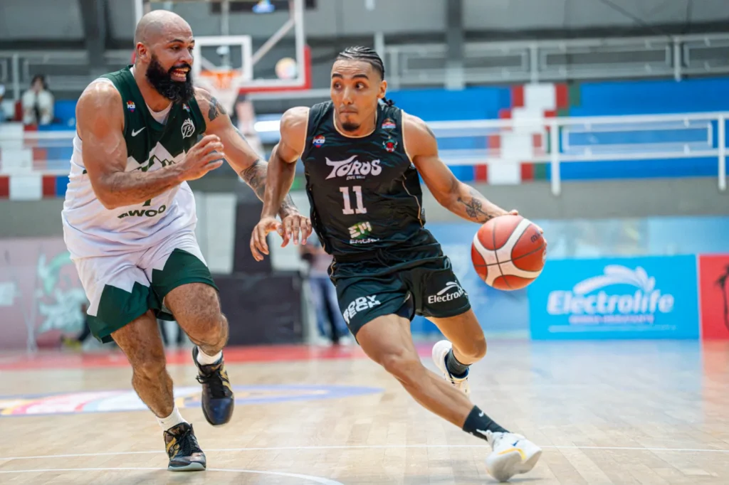 Samuel Mojica penetra con el bal�n ante la marca de un jugador de Paisas Basketball en el Evangelista Mora