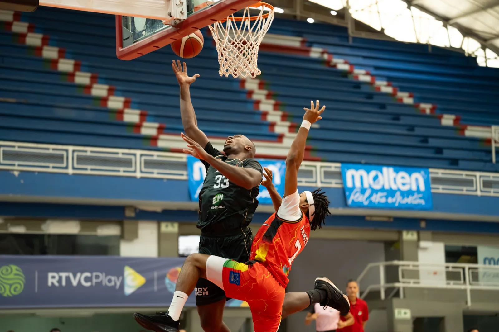 Kevin Quiñones, #33 de Toros del Valle, sube a la bandeja ante la marca de un jugador de Caribbean Storm