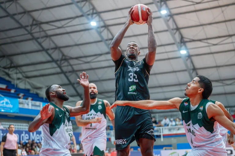 Kevin Qui�ones se eleva con el bal�n para lanzar entre defensores de Paisas Basketball en el Evangelista Mora