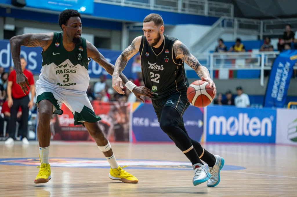 Benito Santiago JR penetra con el bal�n ante la defensa de Paisas Basketball en el Evangelista Mora