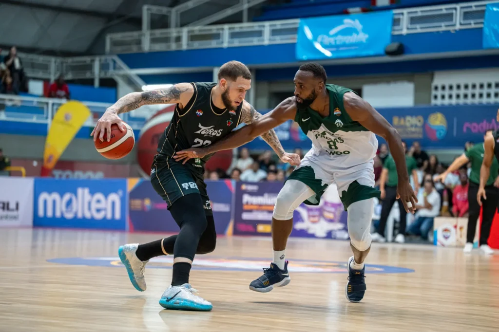 Benito Santiago JR protege el bal�n del defensor de Paisas Basketball en el Evangelista Mora