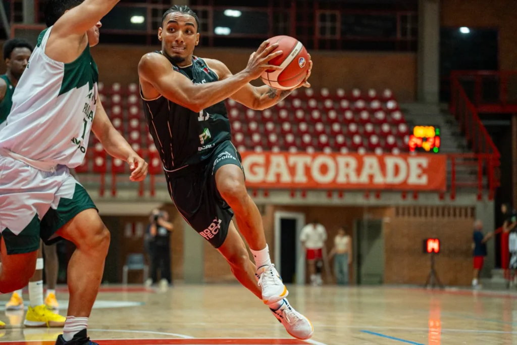 Jugador de Toros del Valle penetra hacia el aro con el balón ante la marca de Paisas Basketball